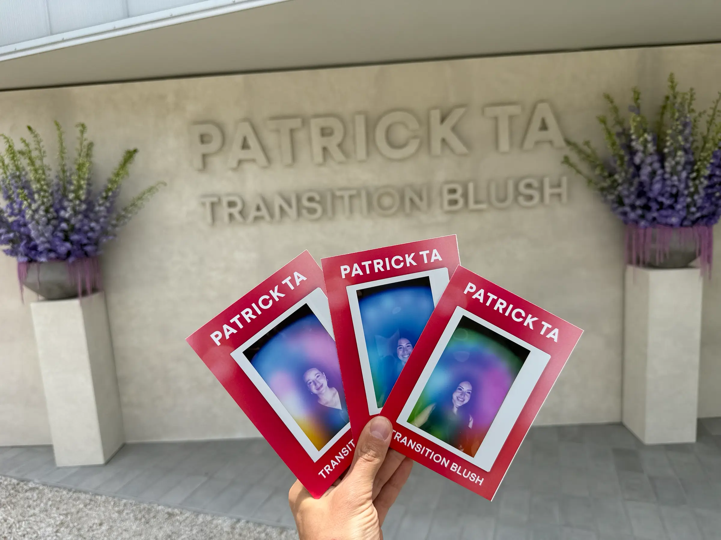 Branded aura photography prints held in front of an event backdrop