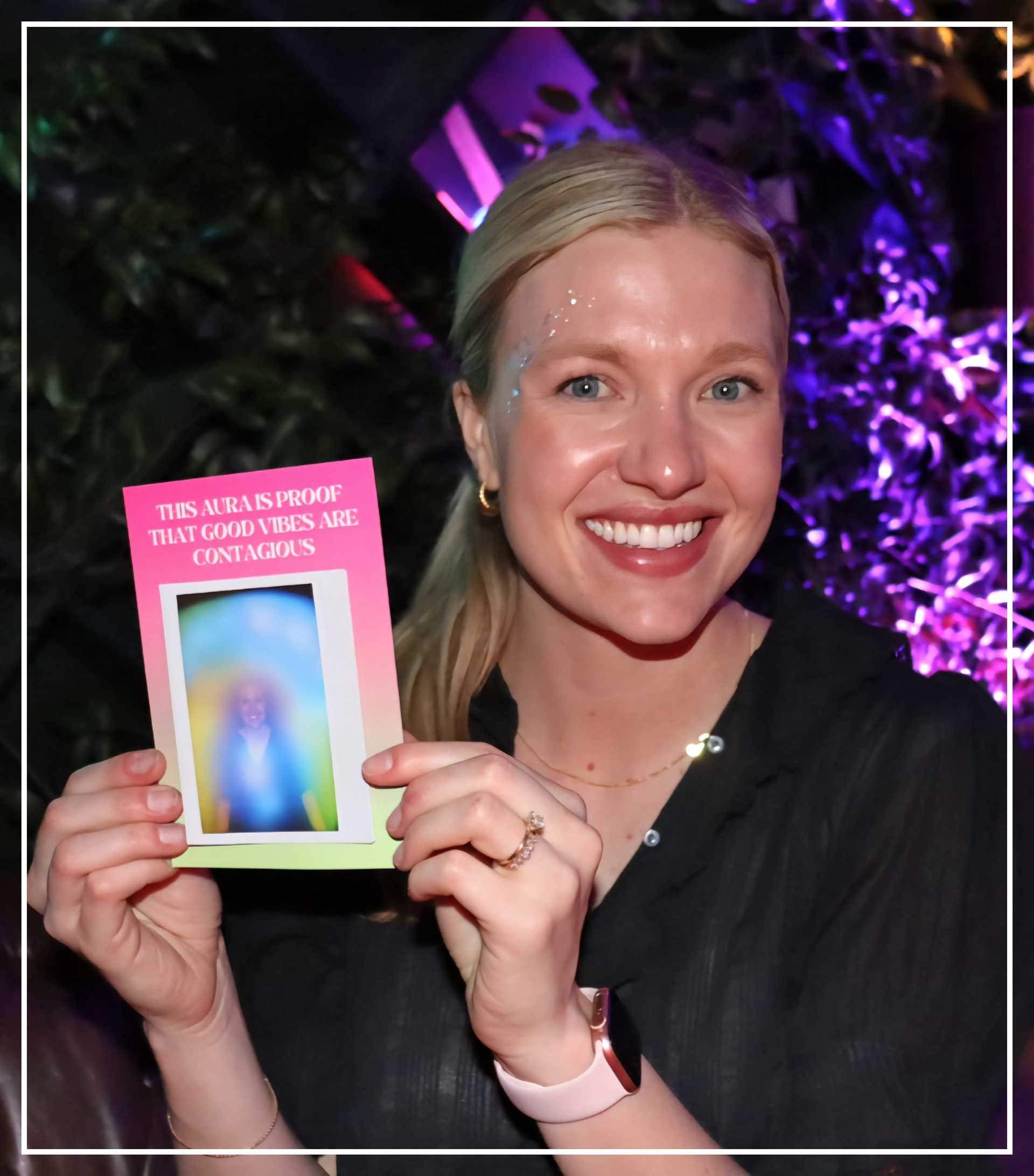 Lady is holding an aura photo in blue yellow green colors in San Diego, California
